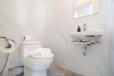 a white bathroom with a toilet and a sink at Villa Serana - New Private Pool Villa in Goldena Residence, Kamala in Kamala Beach