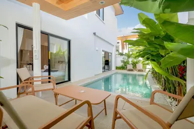 a patio with a pool and tables and chairs at Villa Serana - New Private Pool Villa in Goldena Residence, Kamala in Kamala Beach