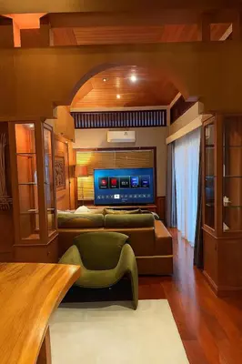 a living room with a couch and a table at Tropical Thai Loft with Koi Pond in Kamala Beach