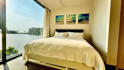 a bedroom with a bed and a large window at Cassia Sea and Pool view 2bd apartments by Aster in Laguna Phuket