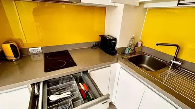 a kitchen with a sink and an open refrigerator at Cassia Sea and Pool view 2bd apartments by Aster in Laguna Phuket
