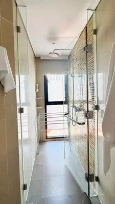 a bathroom with a shower and a glass wall at Cassia Sea and Pool view 2bd apartments by Aster in Laguna Phuket