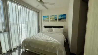 a bedroom with a bed and a large window at Cassia Sea and Pool view 2bd apartments by Aster in Laguna Phuket
