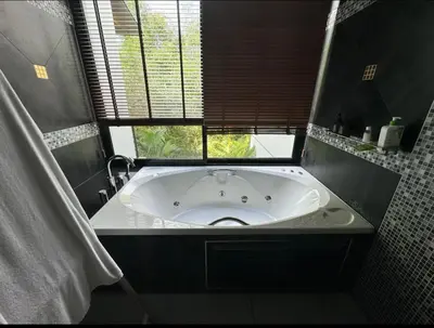 a bath tub in a bathroom with a window at Villa Nature village kamala in Kamala Beach
