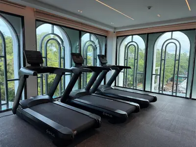 a row of treadmills in a gym with windows at The Title Legendary Bang Tao - Modern 1BR Resort Apartment in Bang Tao Beach