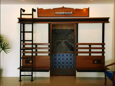 a bunk bed with a ladder next to a room at The Pho Thong Phuket in Phuket Town