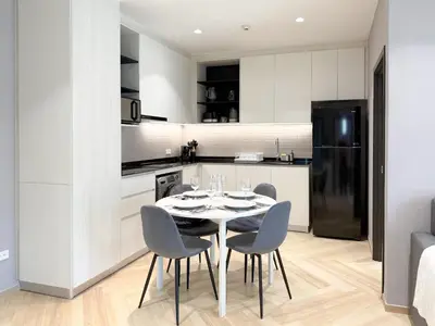 a kitchen and dining room with a table and chairs at Stylish Pool View Apartments Legendary Bangtao by Mango Family in Bang Tao Beach