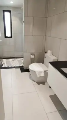 a white bathroom with a toilet and a sink at Stylish Pool View Apartments Legendary Bangtao by Mango Family in Bang Tao Beach