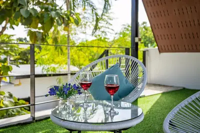 two glasses of wine on a table on a balcony at New! bayfront 2 BR Villa with private pool Nariya V1 - rare find in Phuket in Chalong