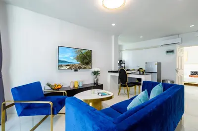 a living room with blue chairs and a table at New! bayfront 2 BR Villa with private pool Nariya V1 - rare find in Phuket in Chalong