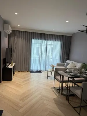 a living room with a table and a couch at The Title Legendary Bang Tao by Tropicana Property in Bang Tao Beach