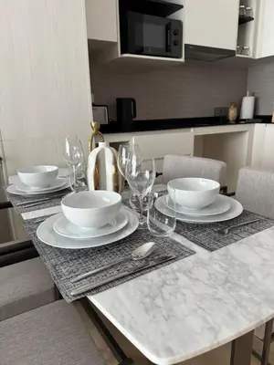 a table with plates and wine glasses on it at The Title Legendary Bang Tao by Tropicana Property in Bang Tao Beach