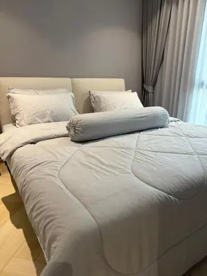 a large bed with a blue pillow on top of it at The Title Legendary Bang Tao by Tropicana Property in Bang Tao Beach