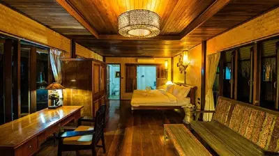 a room with a bed and a table with a bench at Bora Bora Villa Phuket in Chalong
