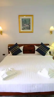 a bedroom with a large white bed with blue pillows at Bora Bora Villa Phuket in Chalong