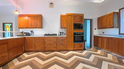a kitchen with wooden cabinets and a wooden floor at Golfer's Getaway 7 Bedroom Pool Villa (SV1) in Phuket Town
