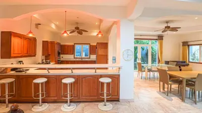 an open kitchen and dining room with a table and chairs at Golfer's Getaway 7 Bedroom Pool Villa (SV1) in Phuket Town