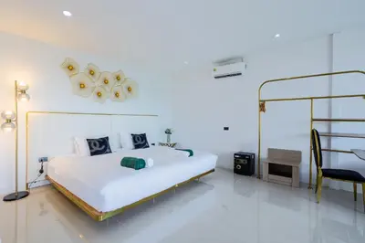 a white bedroom with a bed and a chair at Exclusive! 3-Bedroom Pool Villa with Bay View-Nariya V8 in Chalong