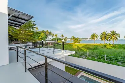 a view of the ocean from the balcony of a house at NEW! 3-Bedroom Pool Villa Overlooking Chalong Bay-Nariya V9 in Chalong