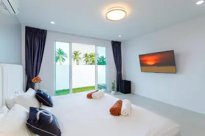 a bedroom with a large white bed with a large window at NEW! 3-Bedroom Pool Villa Overlooking Chalong Bay-Nariya V9 in Chalong