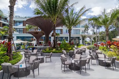 a patio at the resort with chairs and palm trees at Kora Beach Resort 3 bedroom By Ere D118 in Ko Kala