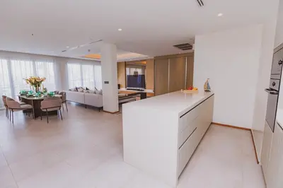 a kitchen and dining room with a white counter and a table at Luxury Angsana Residence in Bang Tao Beach