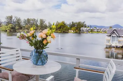 a vase of flowers on a table on a balcony at Luxury Angsana Residence in Bang Tao Beach