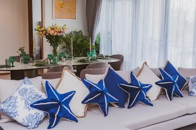 a couch with blue and white pillows on it at Luxury Angsana Residence in Bang Tao Beach