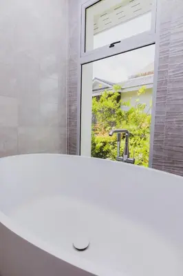 a bathroom with a white sink and a window at Luxury Angsana Residence in Bang Tao Beach