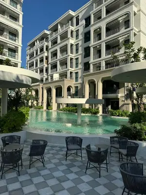 a swimming pool in front of a building at Апартаменты у океана пляж Бангтао Title Legendary Bangtao in Bang Tao Beach