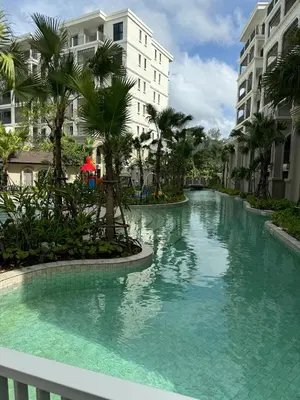 a swimming pool in a resort with palm trees and buildings at Апартаменты у океана пляж Бангтао Title Legendary Bangtao in Bang Tao Beach
