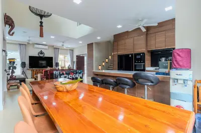 a kitchen with a wooden table and some chairs at V256 Huge Modern 10BR ZipLine 3 Pools Fully Loaded in Rawai Beach