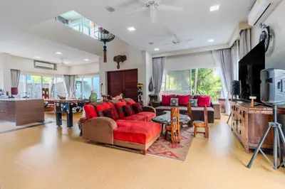 a living room with a red couch and a tv at V256 Huge Modern 10BR ZipLine 3 Pools Fully Loaded in Rawai Beach