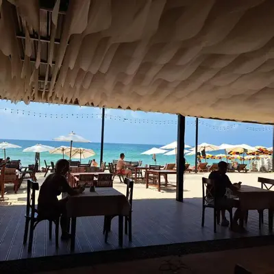 a group of people sitting at tables on the beach at Seashell Family-555\u666e\u5409\u5c9b\u6728\u5c4b\u8d70\u51e0\u6b65\u5230\u90a6\u6d9b\u6d77\u6ee9\u770b\u65e5\u843d\u5468\u8fb9\u9910\u996e\u65b9\u4fbf in Bang Tao Beach