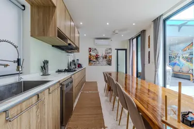 a kitchen with a long counter and a row of chairs at V257 Spacious 5BR Villa Waterfall Pool Movie Room in Rawai Beach