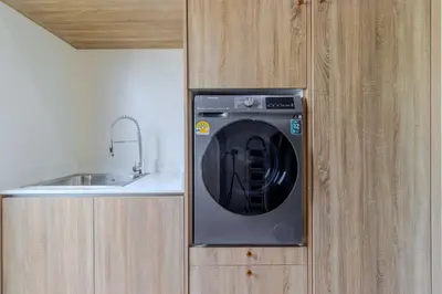 a washing machine in a cabinet next to a sink at V257 Spacious 5BR Villa Waterfall Pool Movie Room in Rawai Beach