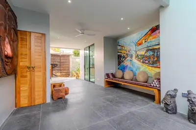 a living room with a large painting on the wall at V257 Spacious 5BR Villa Waterfall Pool Movie Room in Rawai Beach