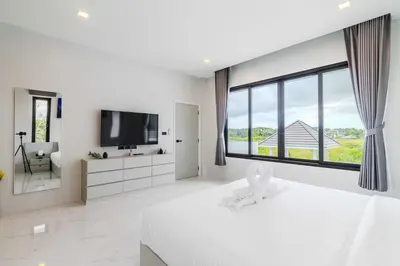 a white bedroom with a large window and a tv at V258 2 Villas 2 Kitchens 2 Livingrooms Huge Pool in Rawai Beach