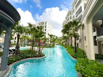 a pool in a resort with palm trees and buildings at The Legendary Bang Tao 2-bedrooms apart #403 in Laguna Phuket