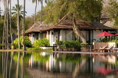 a house with a lake in front of it at The Vijitt Resort - Deluxe Beachfront Villa in Ban Saiyuan (1)