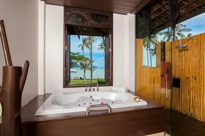 a bath tub in a bathroom with a window at The Vijitt Resort - Deluxe Beachfront Villa in Ban Saiyuan (1)