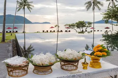 a table with three baskets of flowers on it next to the water at The Vijitt Resort - Vijitt Pool Villa in Ban Saiyuan (1)