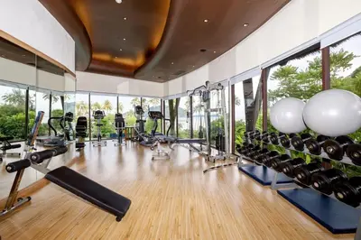 a gym with lots of exercise equipment and windows at The Vijitt Resort - Vijitt Pool Villa in Ban Saiyuan (1)