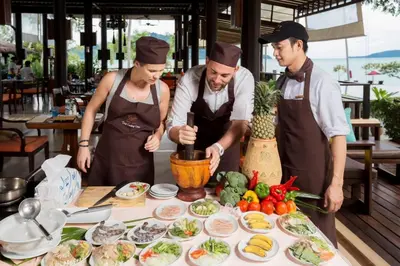 a group of three chefs preparing food on a table at The Vijitt Resort - Vijitt Pool Villa in Ban Saiyuan (1)