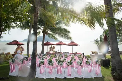 a group of tables with pink chairs and palm trees at The Vijitt - Two Bedroom Pool Villa in Ban Saiyuan (1)