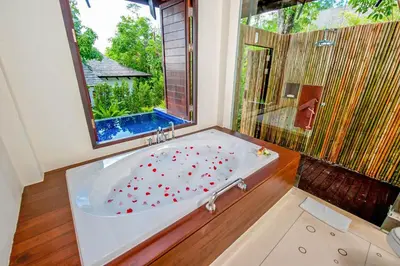 a bathroom with a tub with a large window at The Vijitt - Deluxe Pool Villa in Ban Saiyuan (1)