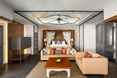 a bedroom with a bed and a couch and a table at Dewa Villa in Nai Yang Beach
