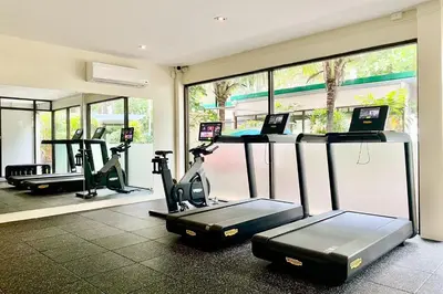 a gym with two treadmills and two exercise bikes at Dewa Villa in Nai Yang Beach