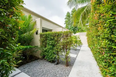 a garden with a walkway next to a building at Dewa Phuket - Deluxe Garden in Nai Yang Beach
