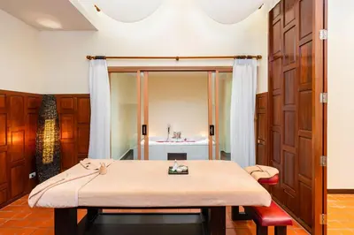 a room with a table and a bed in a room at Naiyang Villa in Nai Yang Beach